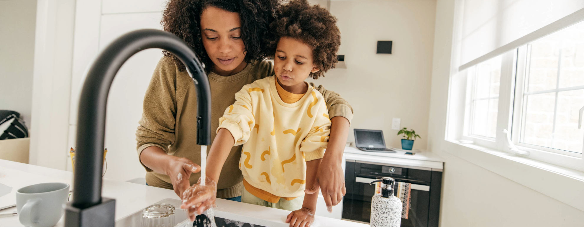 mother and child washing their hands at the sink