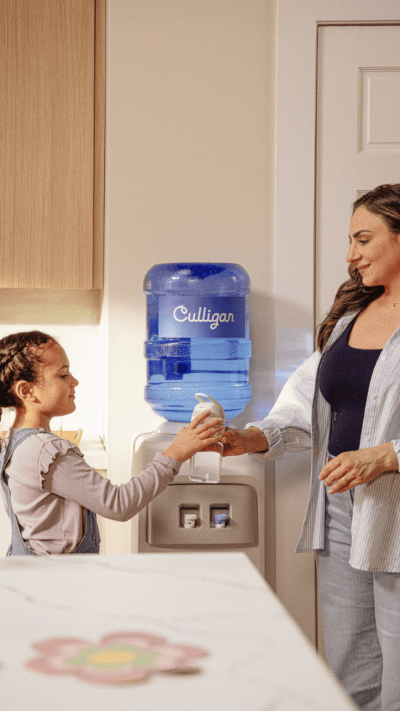Mother and daughter standing near Culligan water cooler